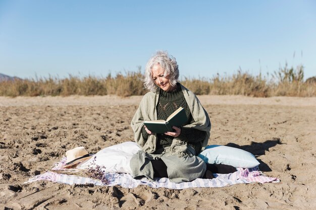 Senior lady reading book outdoors