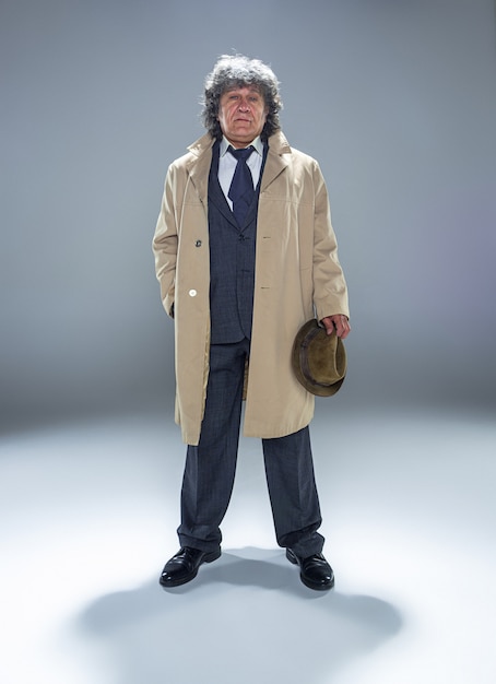 Free photo the senior man as detective or boss of mafia on gray studio background