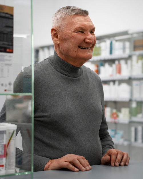Бесплатное фото Старший мужчина покупает лекарства в аптеке