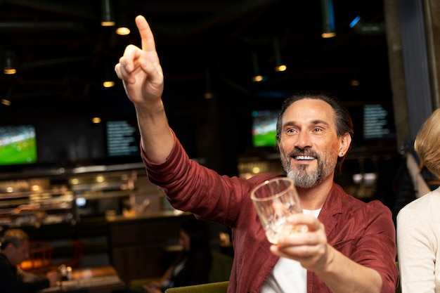 Foto gratuita uomo anziano che chiama il cameriere in un ristorante