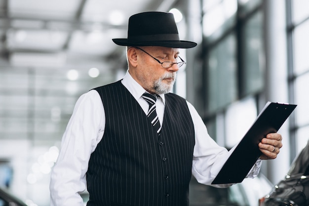 Senior man in a car showroom choosing a car