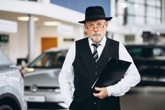 Senior man in a car showroom choosing a car
