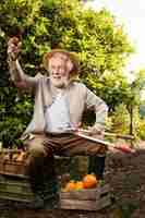 Free photo senior man cultivating oranges