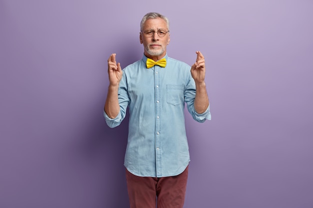 Senior man in denim shirt and yellow bowtie