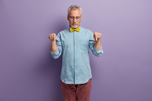 Senior man in denim shirt and yellow bowtie