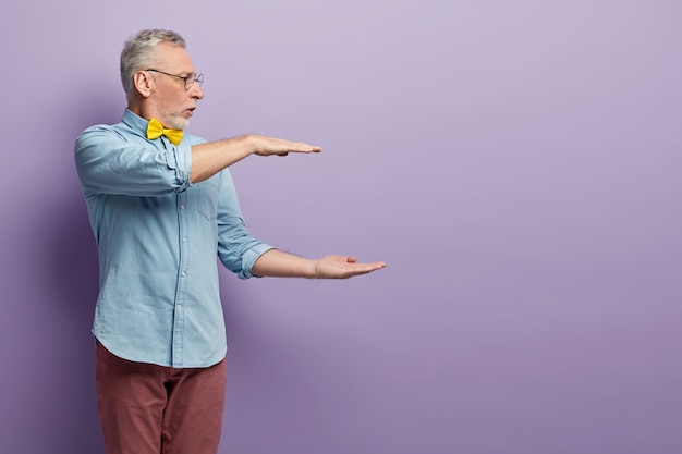 Senior man in denim shirt and yellow bowtie