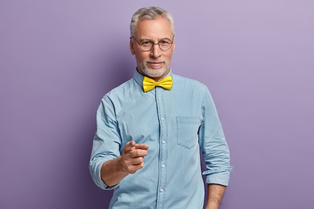 Senior man in denim shirt and yellow bowtie