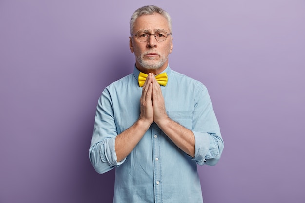 Senior man in denim shirt and yellow bowtie