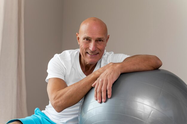 Senior man doing exercises with fitness ball