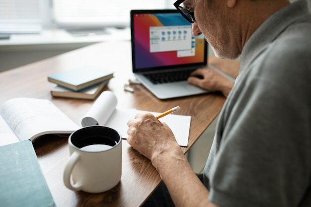 Senior man doing online classes on a laptop at home