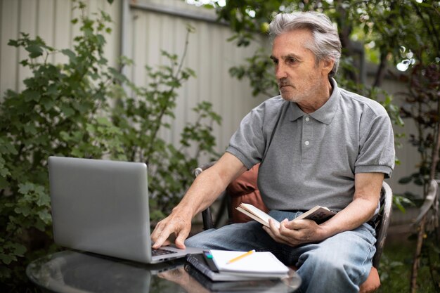 ノートパソコンでオンラインクラスをやっている年配の男性