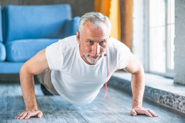 Senior man doing pushup at home