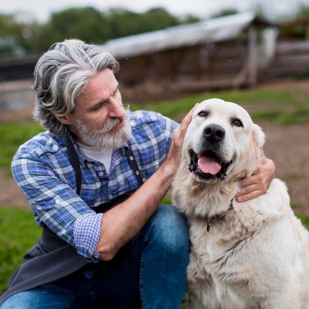 犬と一緒に農場で年配の男性