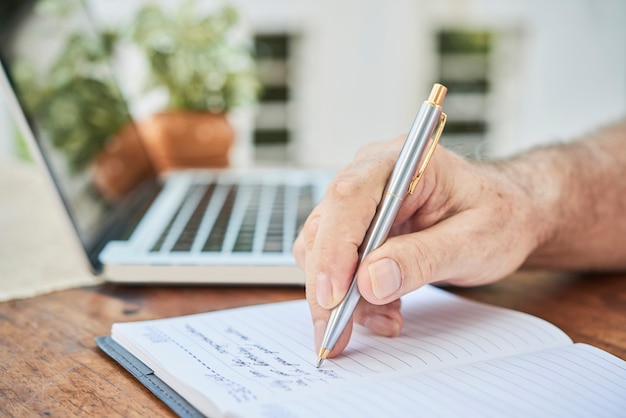 Senior man filling diary