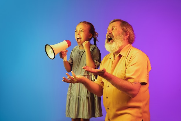 Senior man and granddaughter on neon