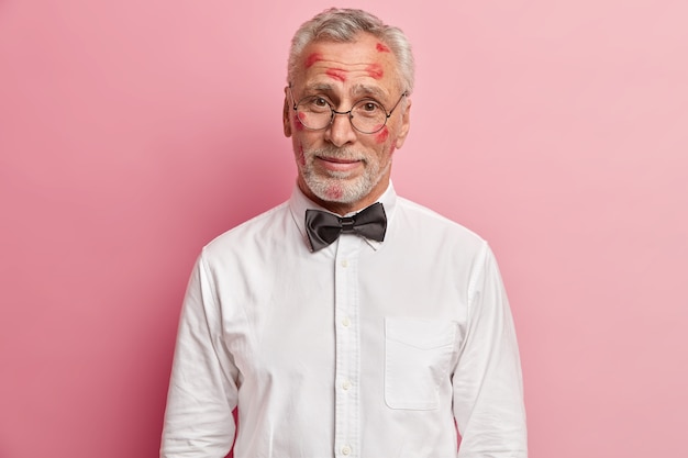 Senior man having lipstick stains on face