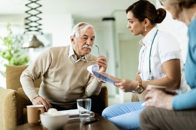 Senior man and healthcare worker going through medical reports during home visit