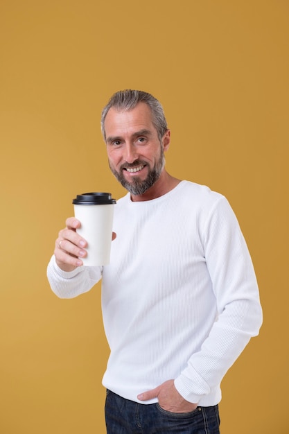 Старший мужчина держит чашку кофе