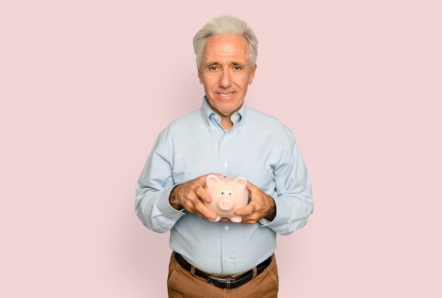 Senior man holding piggy bank for financial savings campaign