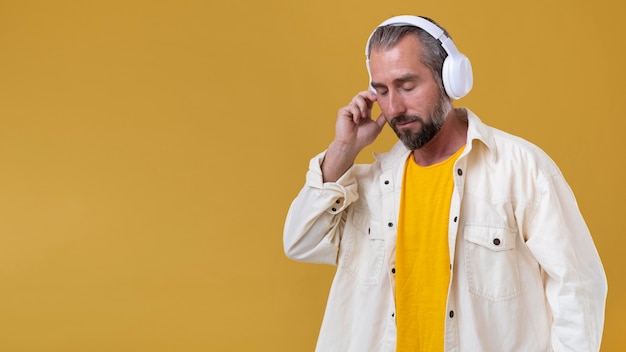 Senior man listening to music through headphones