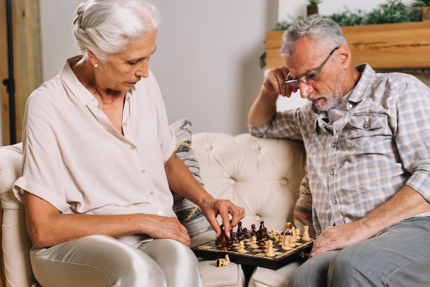 Senior man looking at her wife playing chess