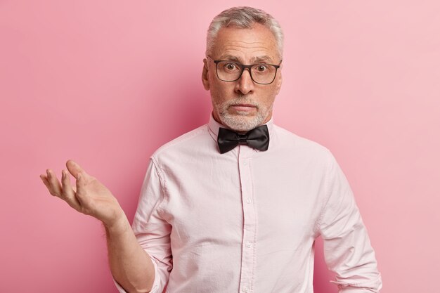 Senior man in pink shirt and black bowtie