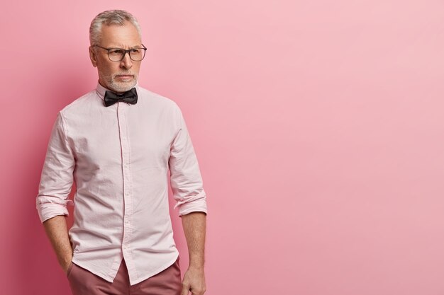 Senior man in pink shirt and black bowtie