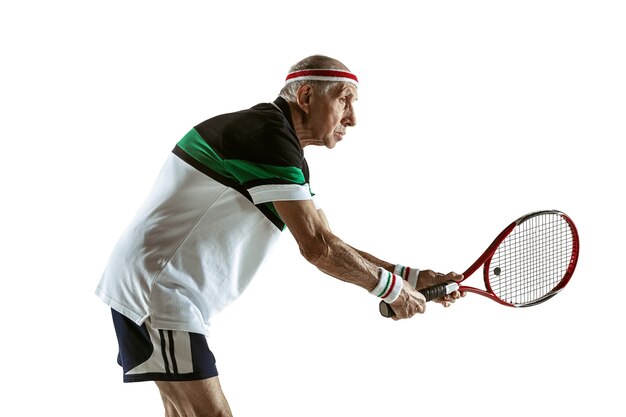 Senior man playing tennis in sportwear isolated on white wall