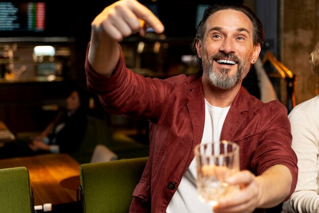 Senior man pointing at his empty glass at a restaurant