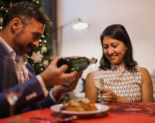 Uomo anziano versando champagne a sua moglie