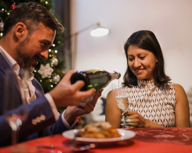 Senior man pouring champagne to his wife