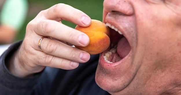 Бесплатное фото Старший мужчина готов откусить персик