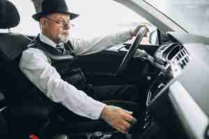 Free photo senior man sitting inside a car