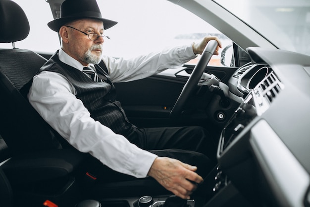 Senior man sitting inside a car