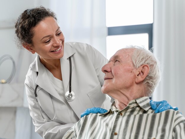 Senior man sitting in wheelchair next to a doctor