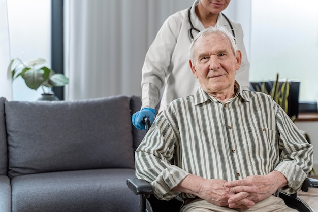 Senior man sitting in wheelchair next to a doctor