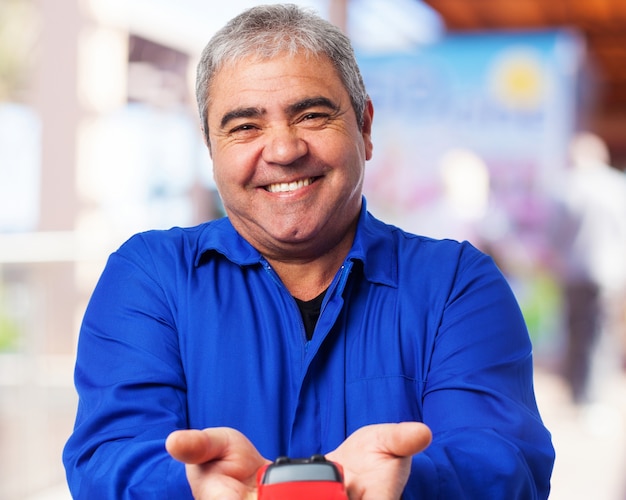 Senior man smiling with a red toy stroller