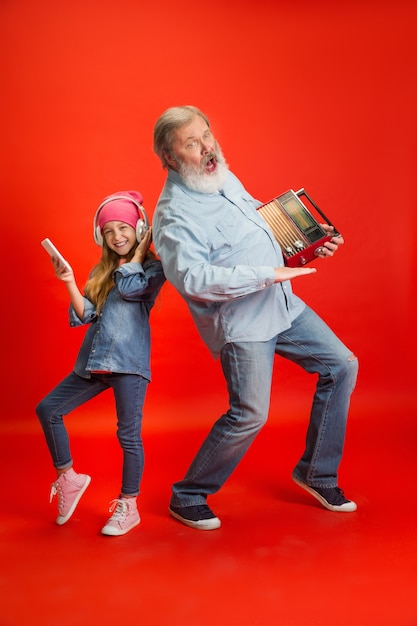 Senior man spending happy time with granddaughter in neon