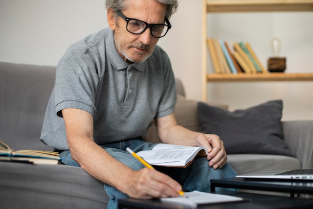 Free photo senior man taking notes in class