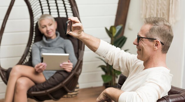 年配の男性が彼の妻の隣にselfieを取って