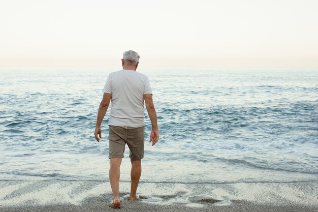 ビーチを一人で歩く年配の男性