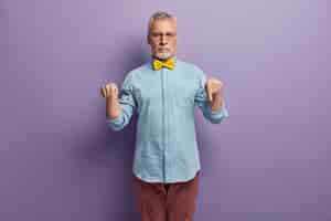 Free photo senior man wearing blue shirt and yellow bowtie