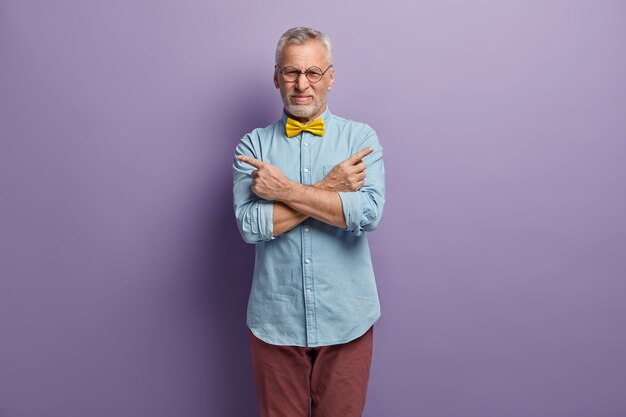 Free photo senior man wearing blue shirt and yellow bowtie