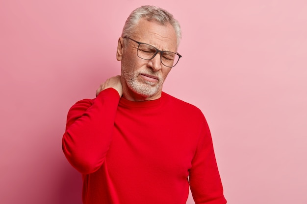 Бесплатное фото Старший мужчина в красном свитере и модных очках