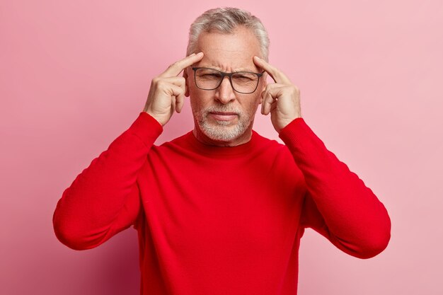 Senior man wearing red sweater and trendy eyeglasses