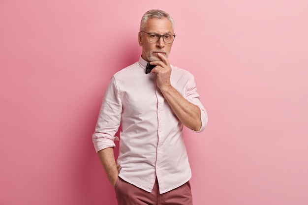 Uomo maggiore che indossa una camicia bianca e papillon nero