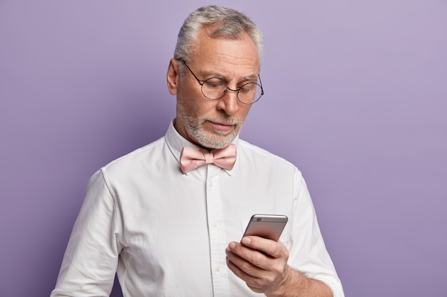 Senior man wearing white shirt and pink bowtie