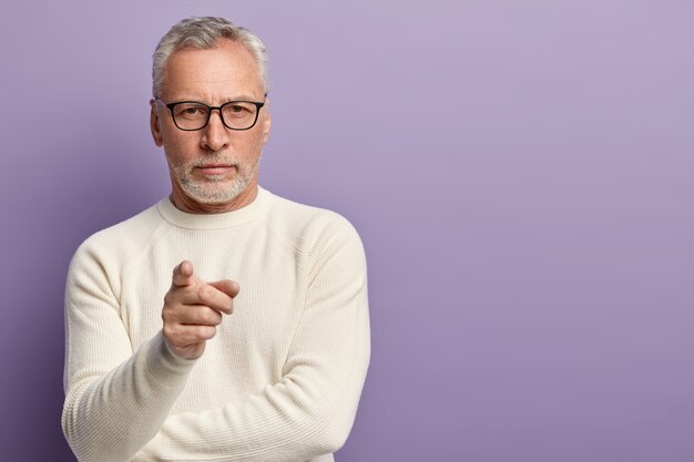 Senior man wearing white sweater and trendy eyeglasses