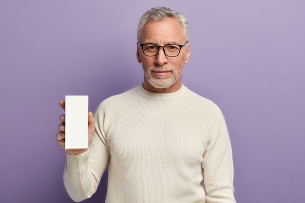 Senior man wearing white sweater and trendy eyeglasses