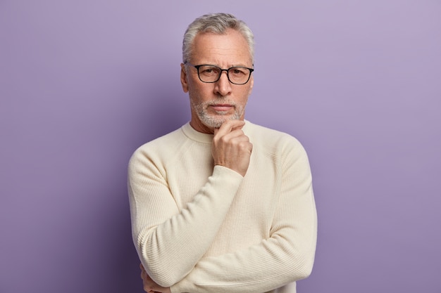 Senior man in white sweater and eyeglasses
